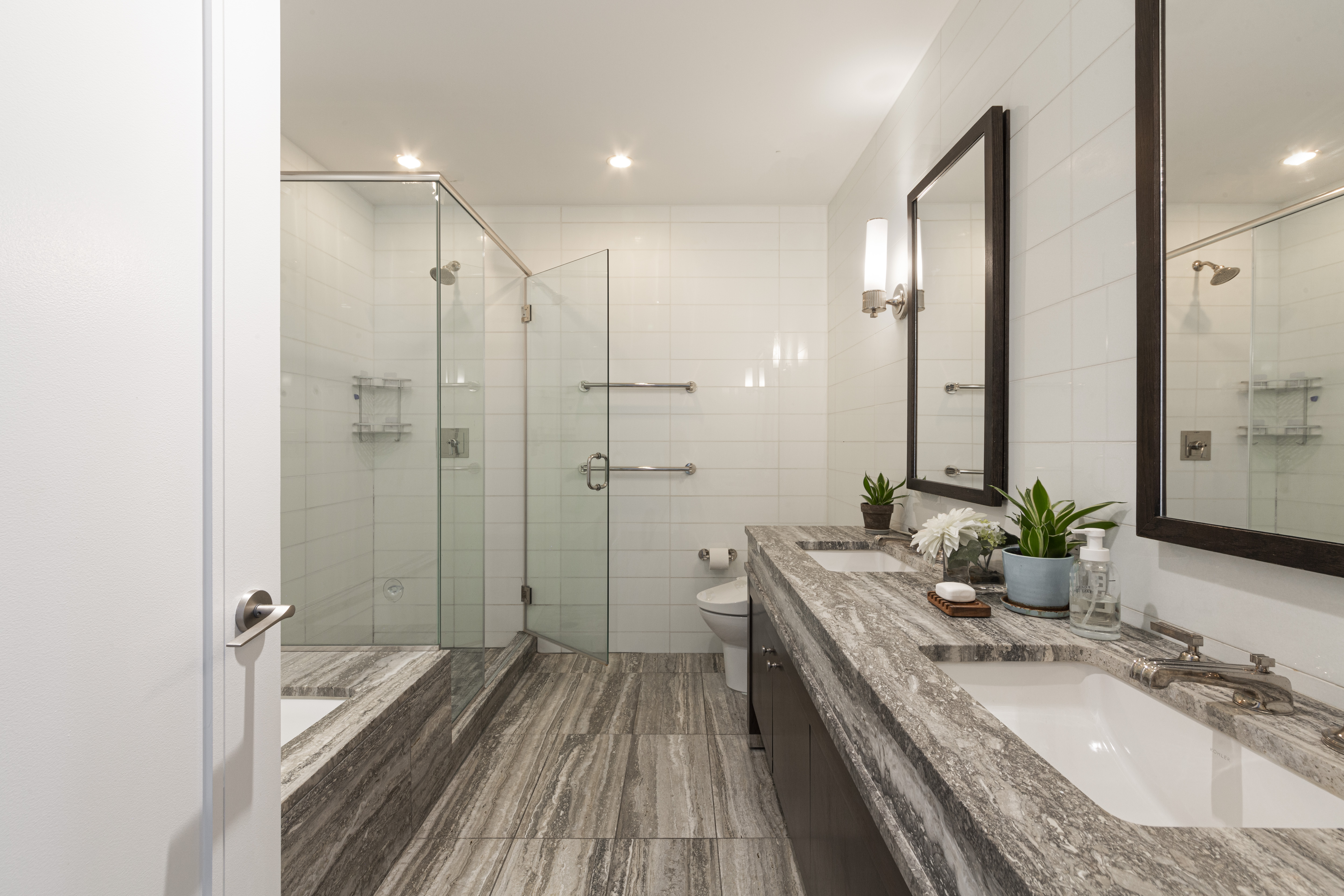 80 Riverside Boulevard, Unit 9E Manhattan, NY 10069 - Photo 8 of 14 a bathroom with a granite countertop double vanity sink a large mirror a shower and a bathtub