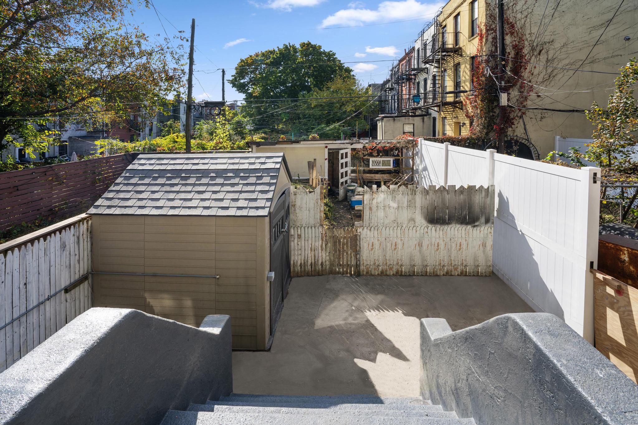 1328 Herkimer Street, Unit 1 Brooklyn, NY 11233 - Photo 9 of 9 a view of a patio with table and chairs with wooden floor and fence