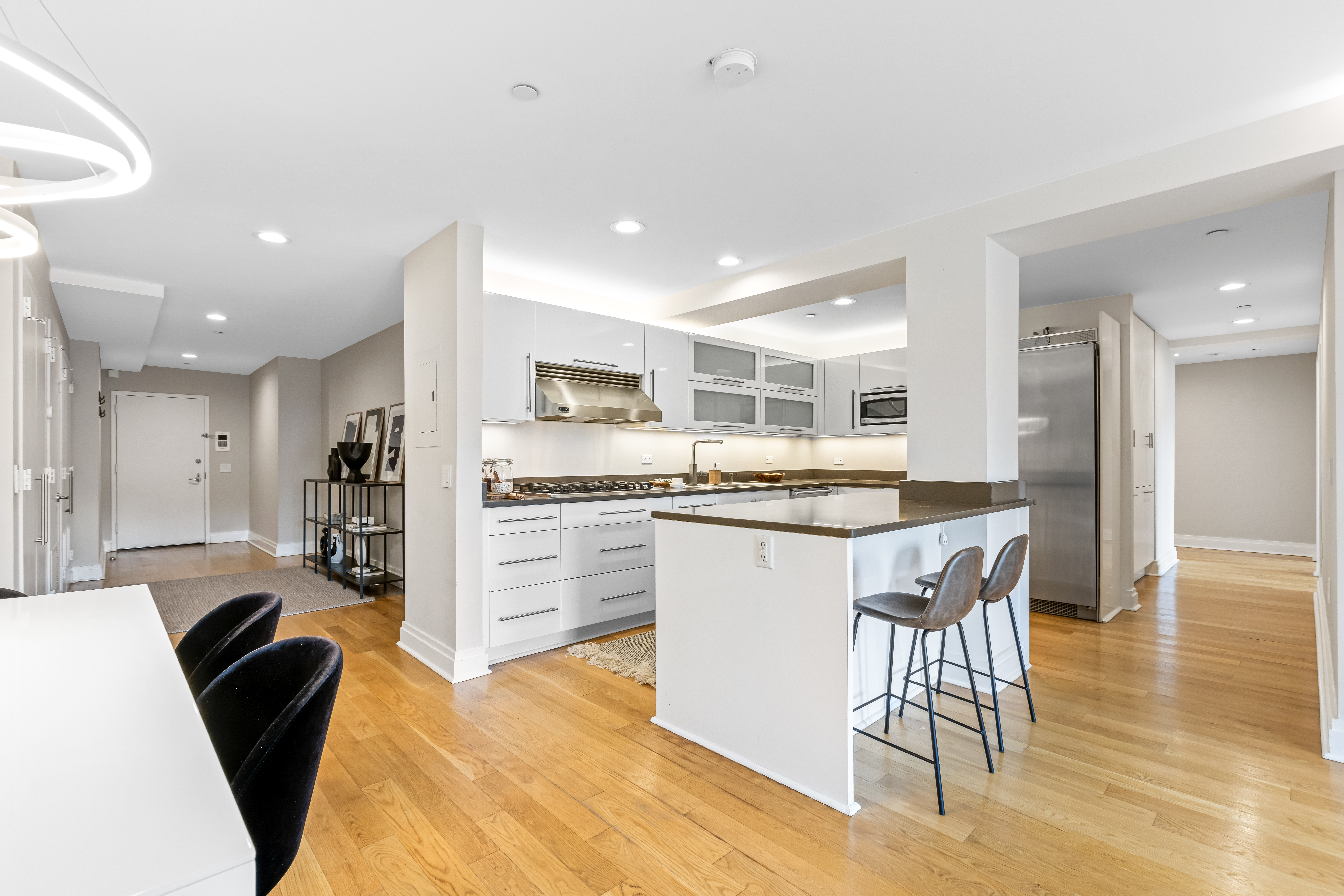 257 West 117th Street, Unit 6A Manhattan, NY 10026 - Photo 5 of 16 a kitchen with stainless steel appliances kitchen island granite countertop a refrigerator a stove a sink dishwasher with a dining table and chairs