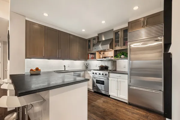 a kitchen with kitchen island a stove a sink and a refrigerator
