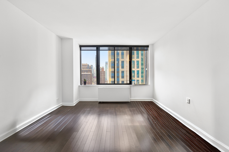 445 5th Avenue, Unit 26F Manhattan, NY 10016 - Photo 2 of 11 an empty room with wooden floor and windows