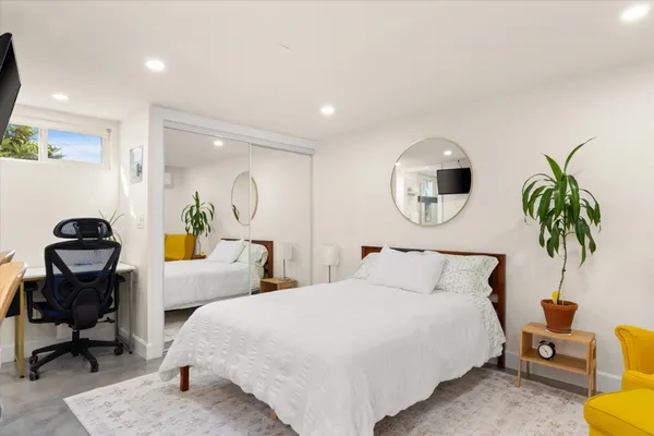 a bedroom with a bed a table and painting on the wall