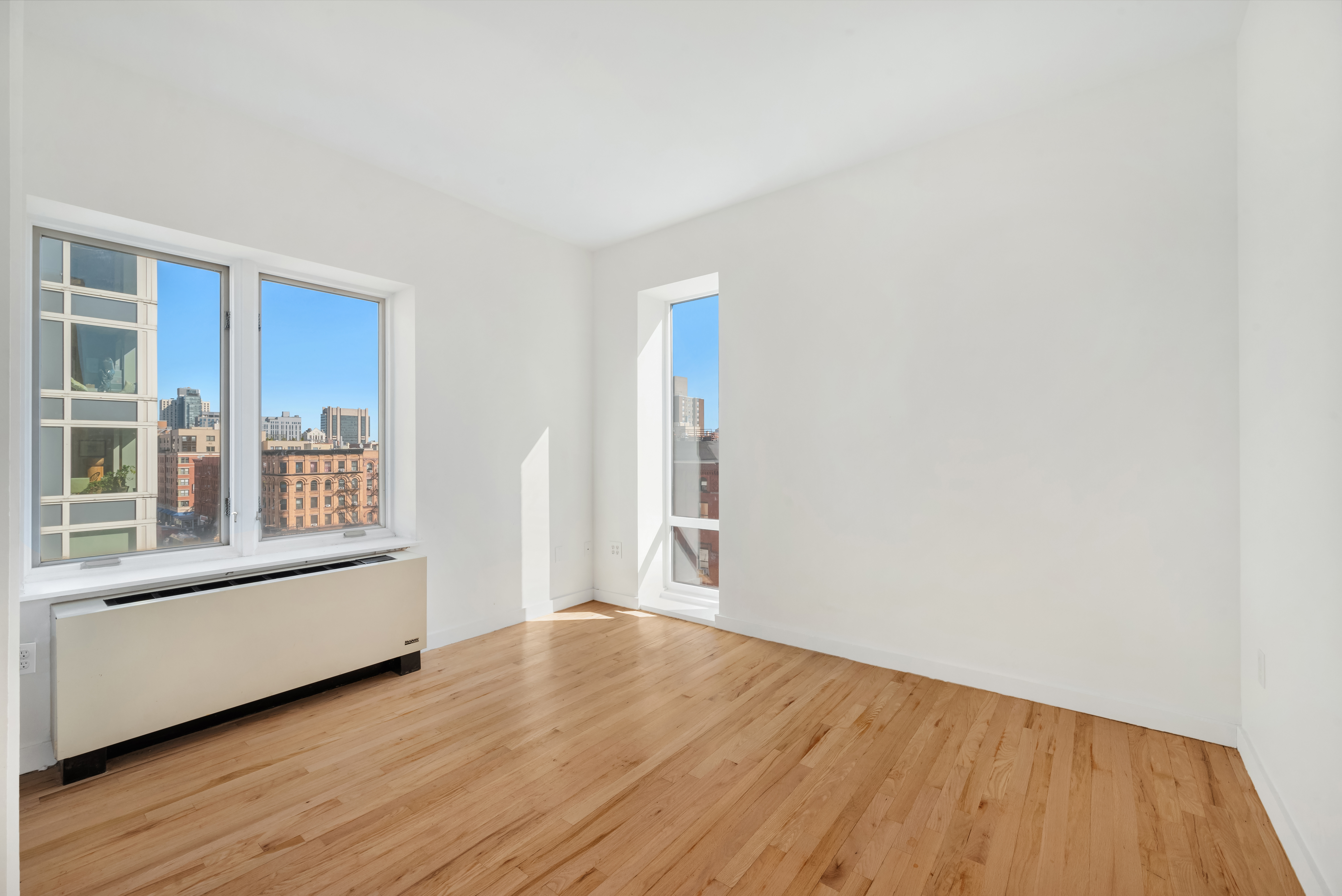 304 West 115th Street, Unit 6A Manhattan, NY 10026 - Photo 6 of 14 a view of an empty room with wooden floor and a window