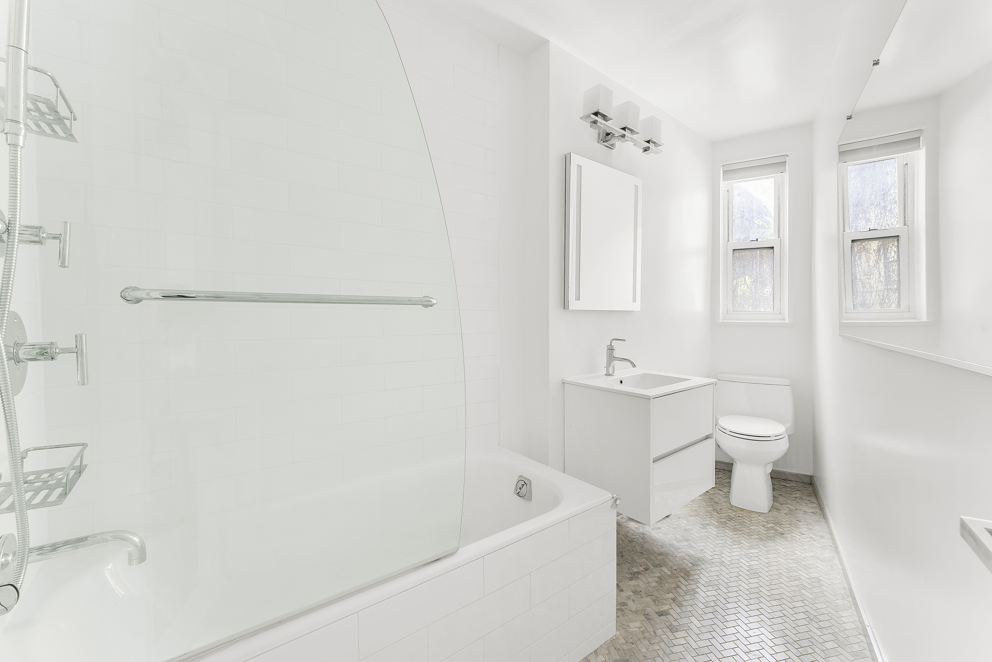 100 Bank Street, Unit 1H Manhattan, NY 10014 - Photo 7 of 10 a bathroom with a toilet a sink a mirror a bathtub and shower