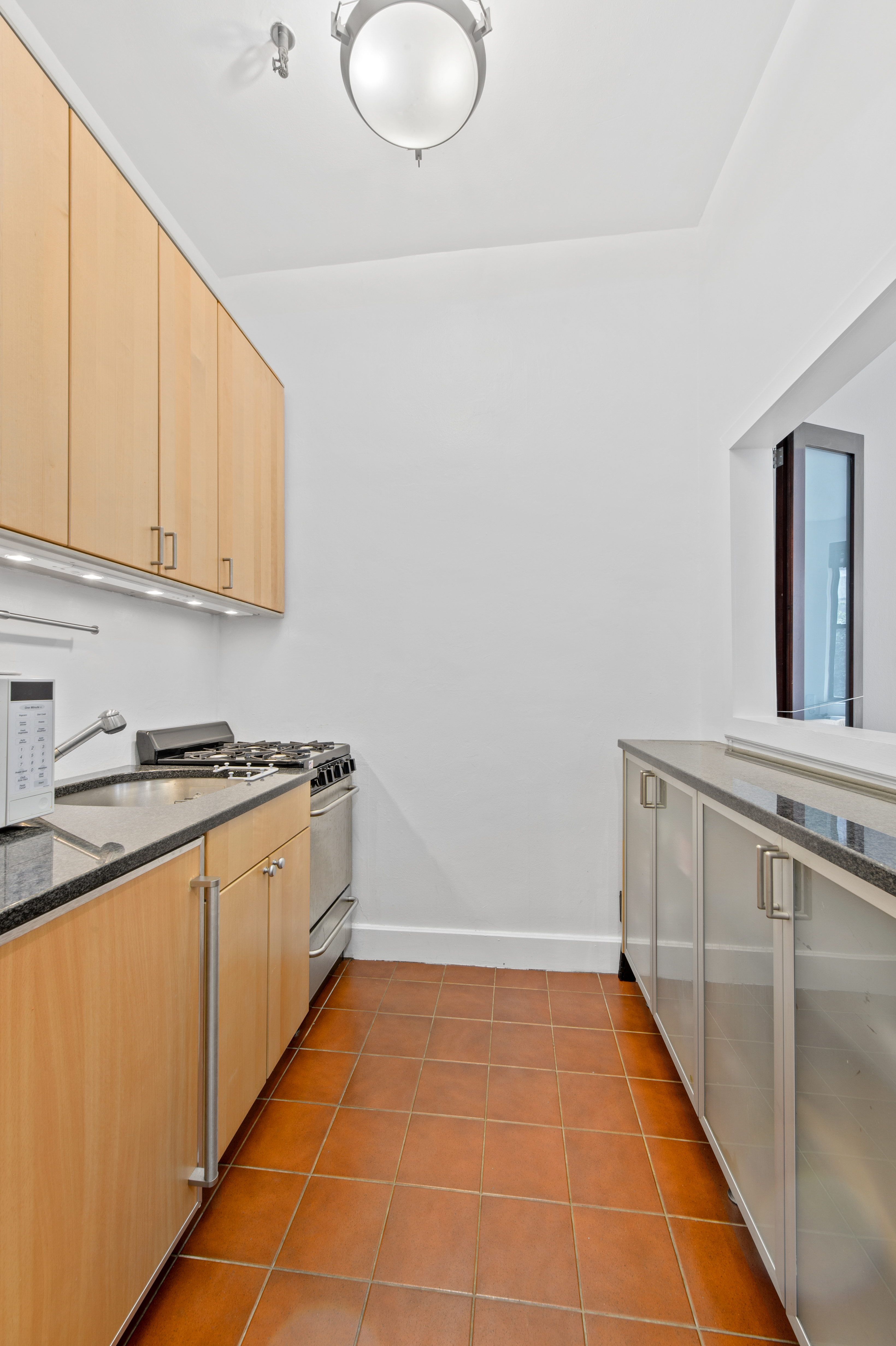 340 East 83rd Street, Unit 1A Manhattan, NY 10028 - Photo 3 of 6 a kitchen with a sink and cabinets