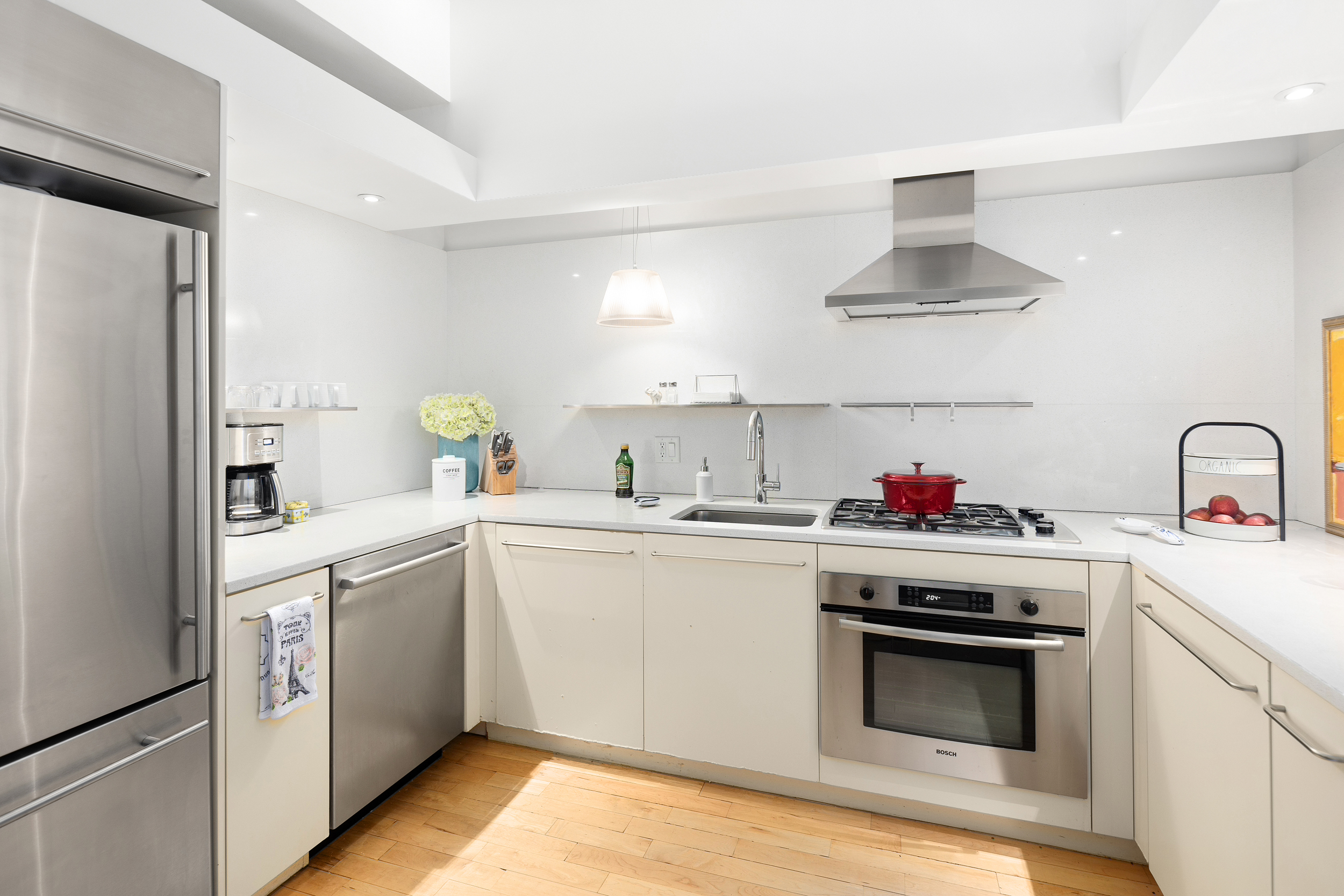 15 Broad Street, Unit 2404 Manhattan, NY 10005 - Photo 4 of 23 a kitchen with a sink stainless steel appliances and cabinets