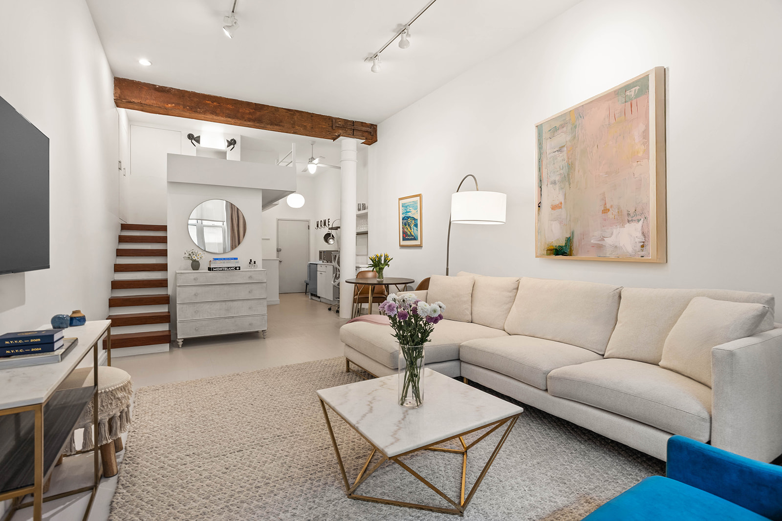 a living room with furniture a desk and chair with wooden floor