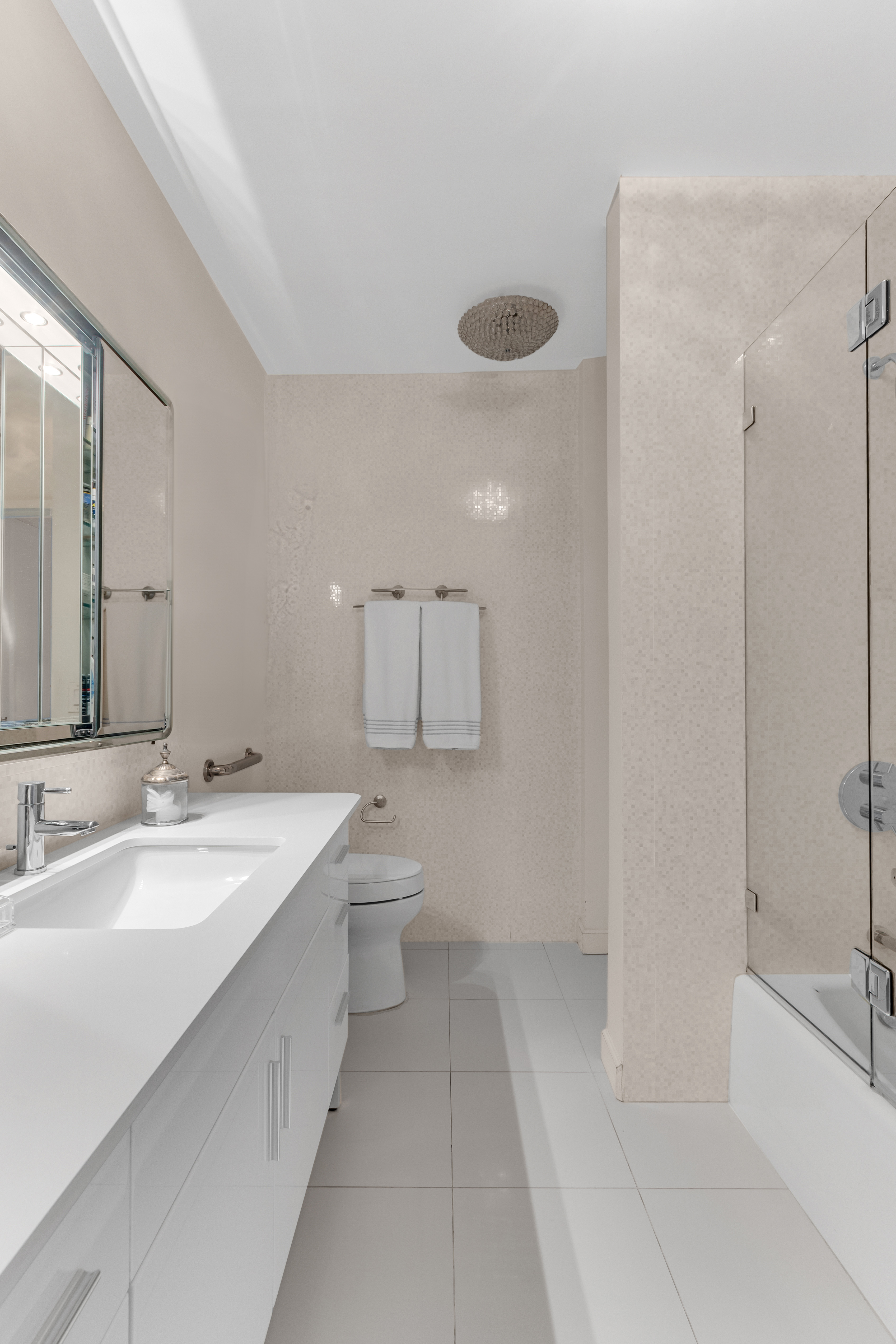 167 East 61st Street, Unit 7D Manhattan, NY 10065 - Photo 5 of 8 a bathroom with a sink a toilet and shower