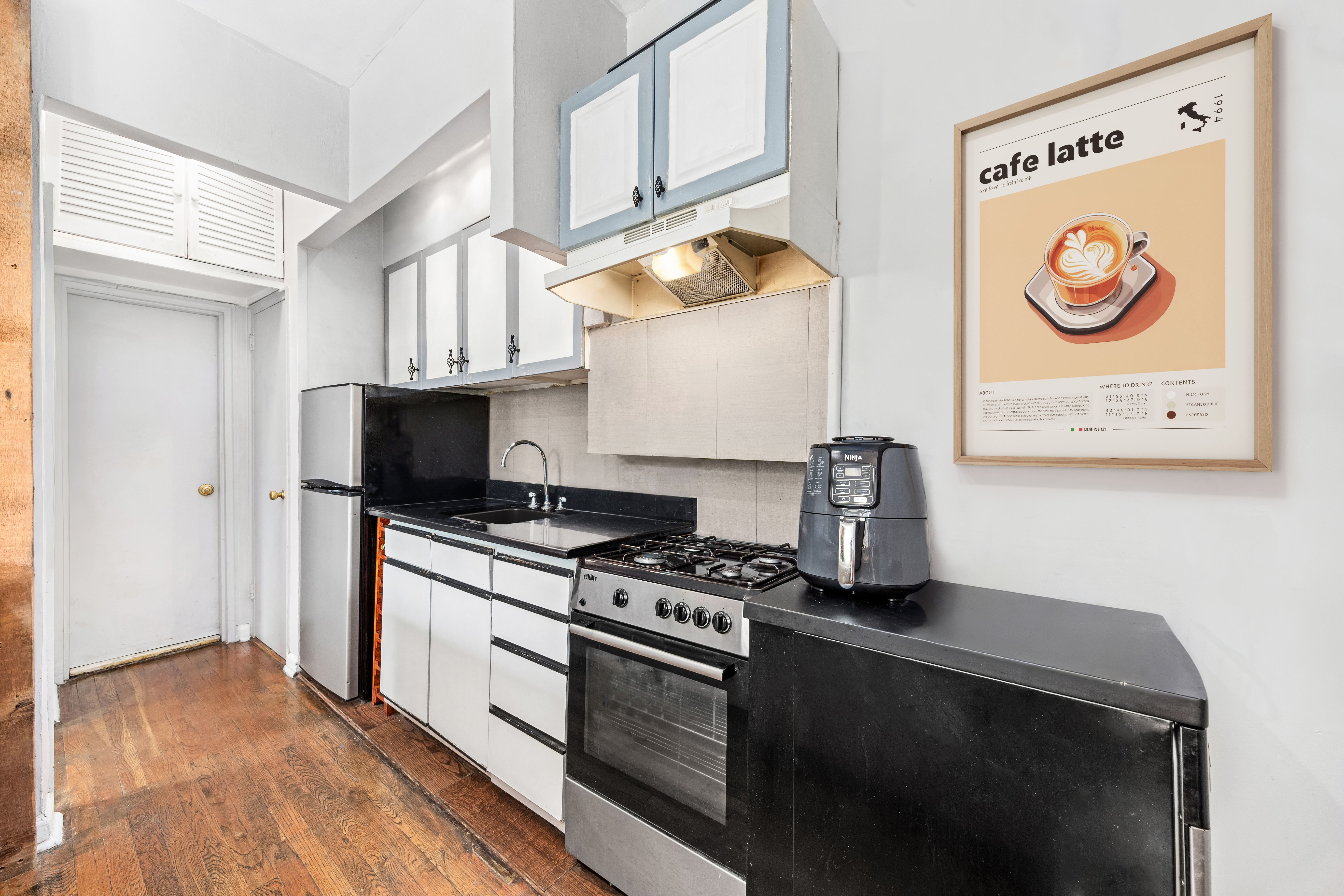 459 Hudson Street, Unit 2A Manhattan, NY 10014 - Photo 2 of 7 a kitchen with stainless steel appliances a stove a microwave and a refrigerator