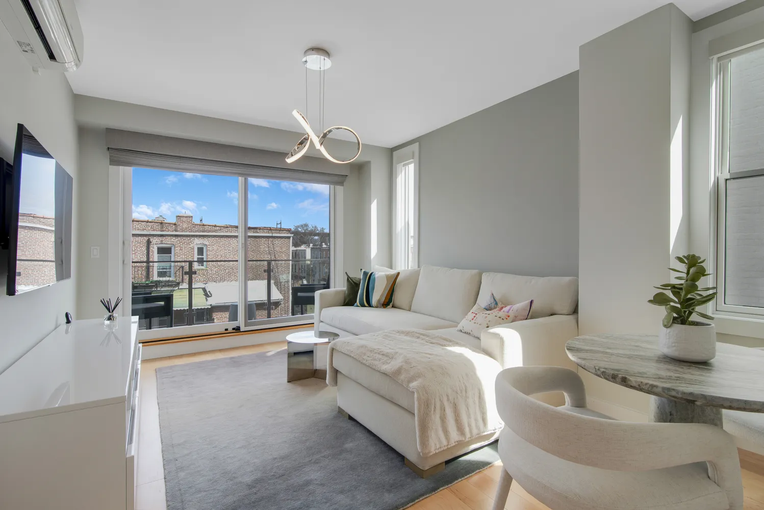 a living room with furniture a chandelier and a flat screen tv