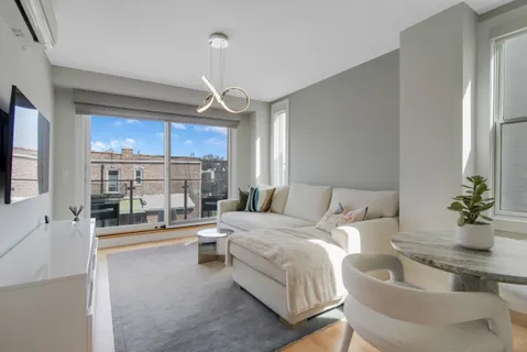 a living room with furniture a chandelier and a flat screen tv