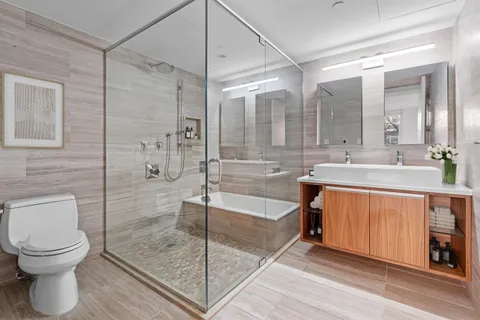 a bathroom with a double vanity sink toilet and shower
