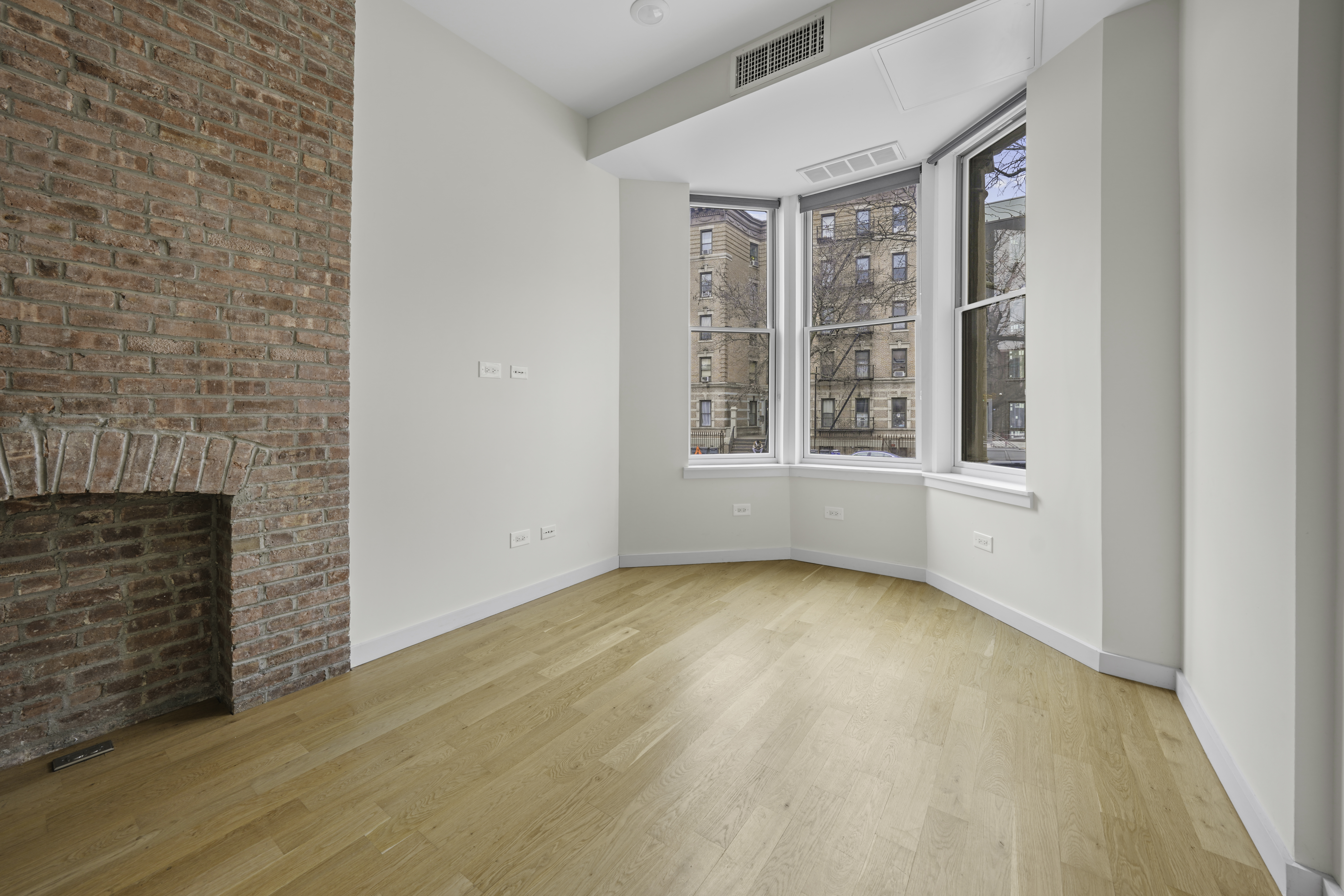 950 St Nicholas Avenue, Unit 1 Manhattan, NY 10032 - Photo 1 of 16 a view of an empty room with a fireplace and a window