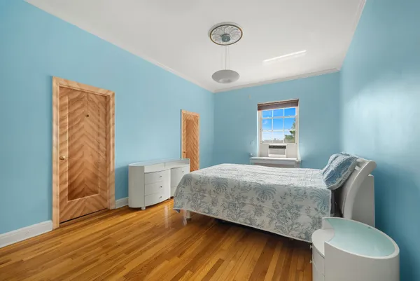 a bedroom with a bed and wooden floor