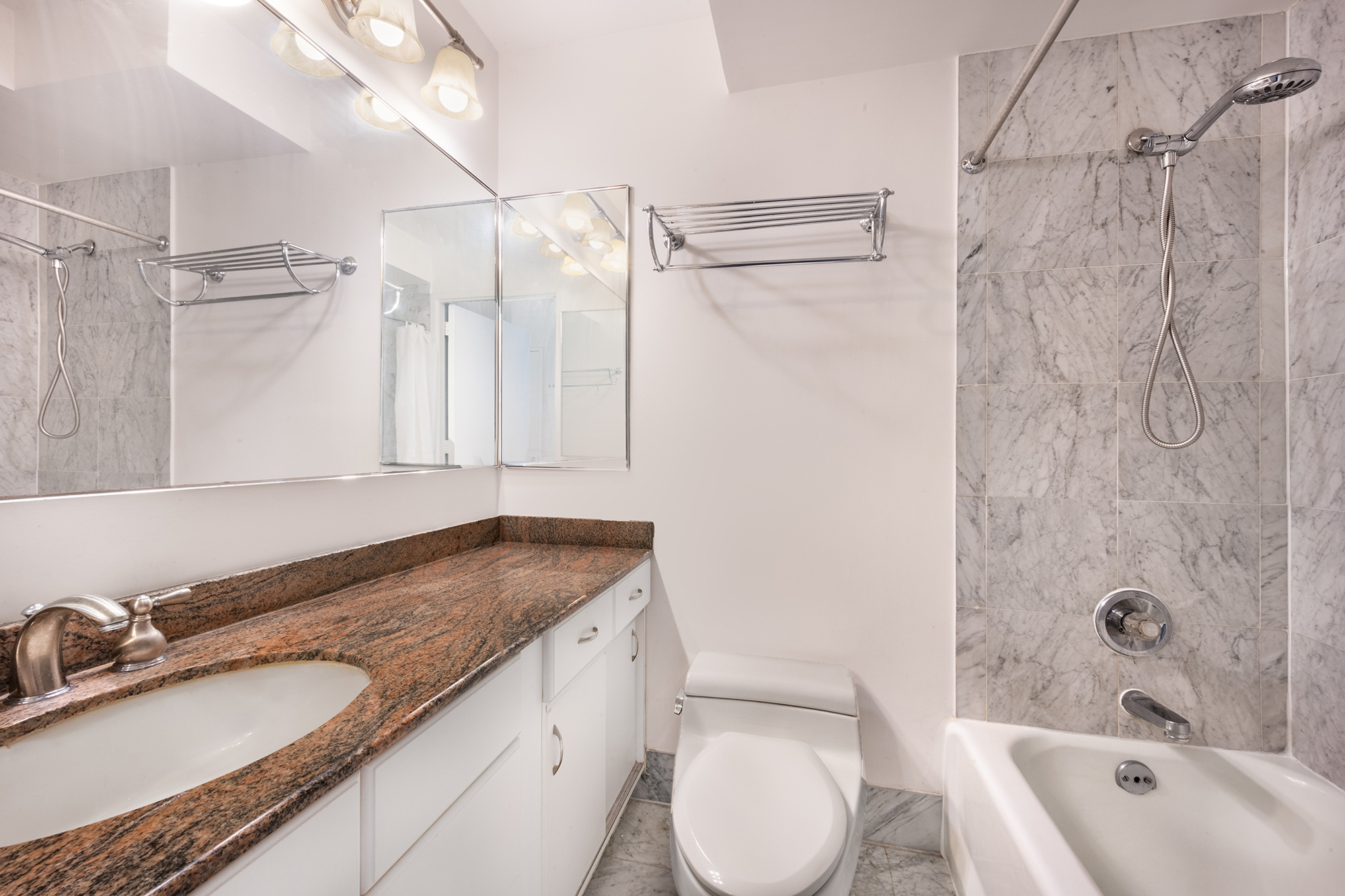330 East 38th Street, Unit 41H Manhattan, NY 10016 - Photo 5 of 6 a bathroom with a granite countertop sink toilet and shower