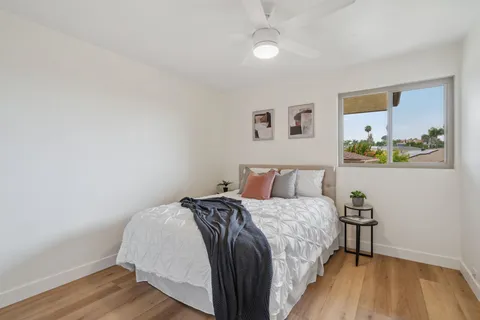 a bedroom with a bed and painting on the wall