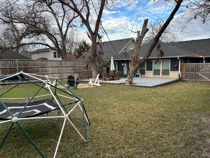 a view of a house with backyard and sitting area