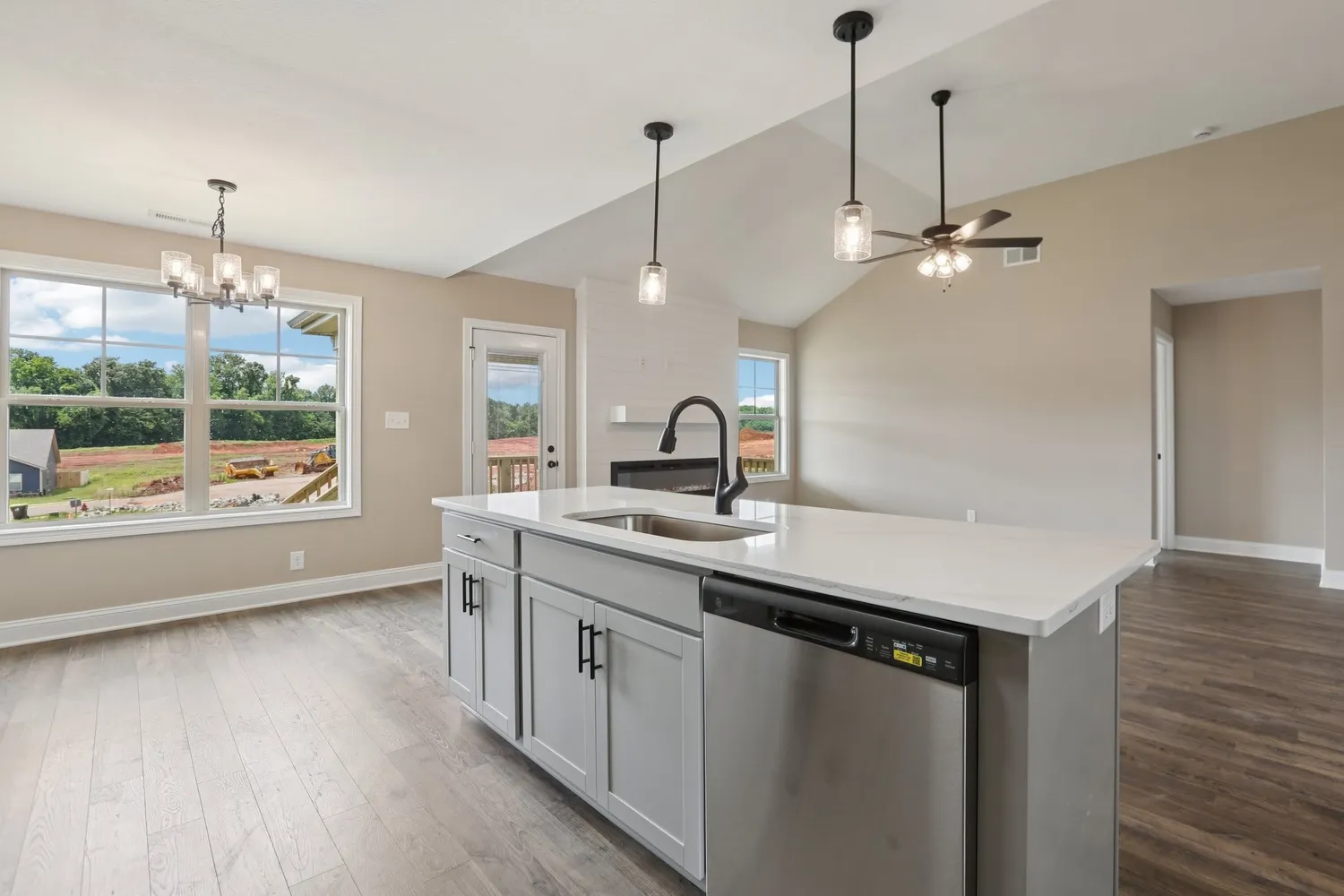 a kitchen with a sink a center island and wooden floor