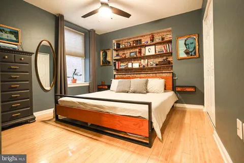 a bedroom with a bed lamp and a large window