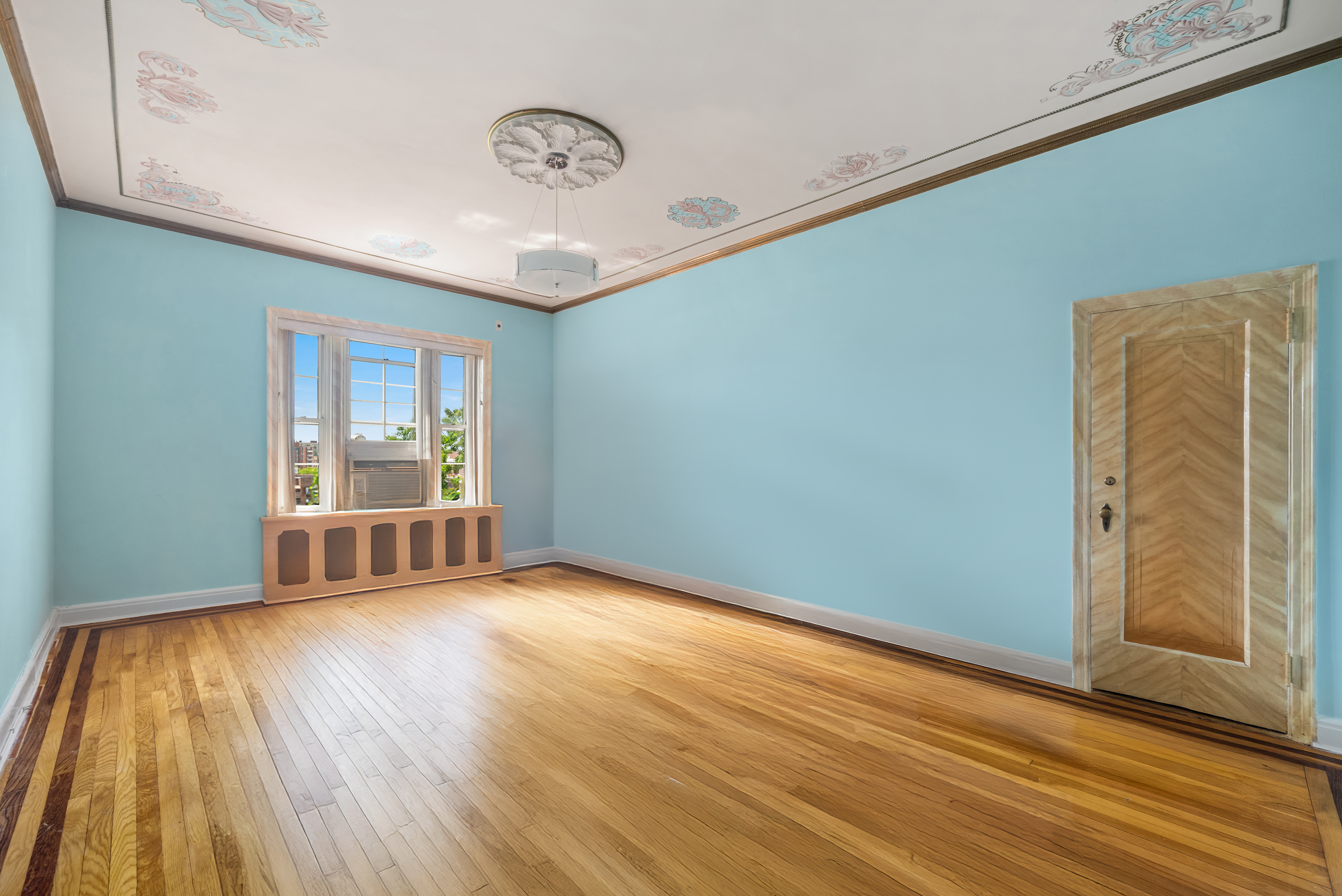 68-10 108th Street, Unit 6D Queens, NY 11375 - Photo 12 of 15 a view of an empty room with wooden floor and a window