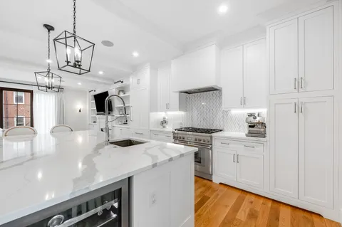 a kitchen with stainless steel appliances granite countertop a sink a stove and a refrigerator