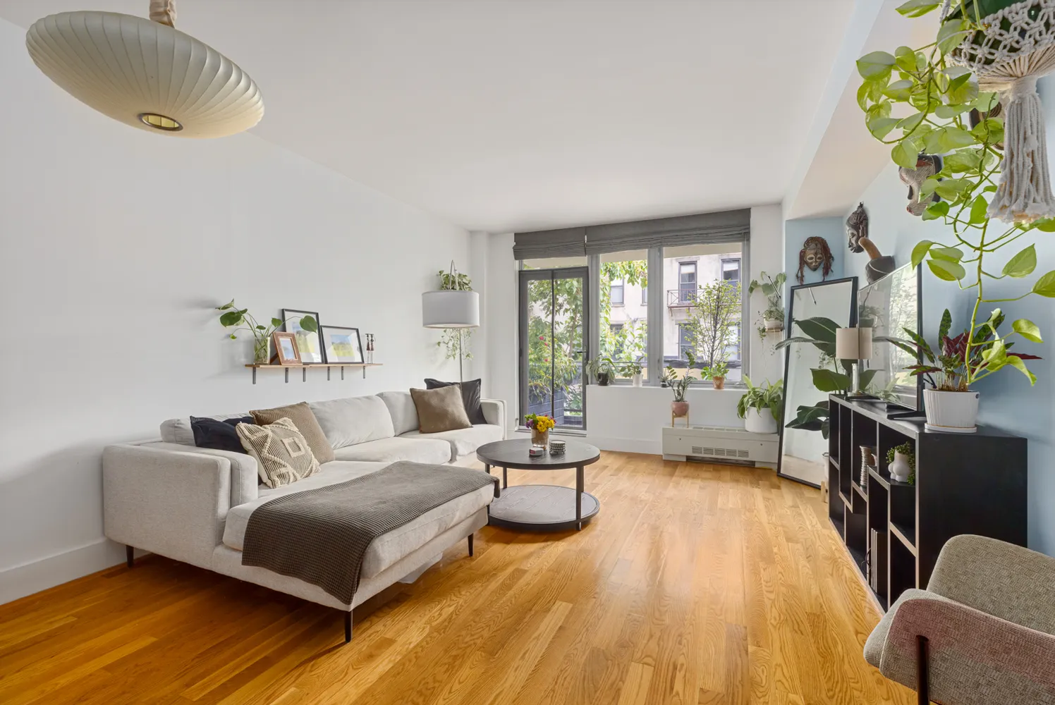 a spacious bedroom with a bed a couch and a potted plant