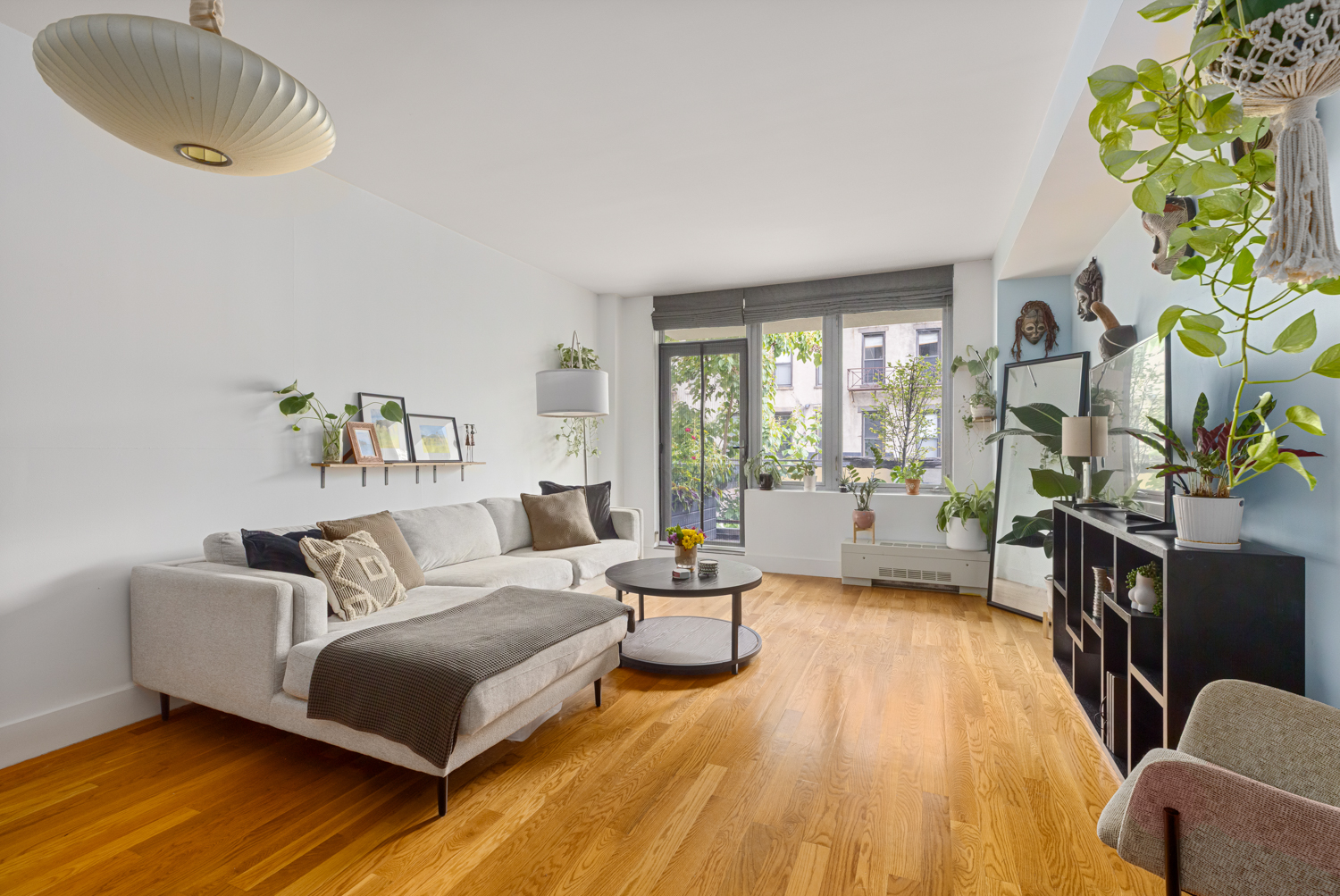 a spacious bedroom with a bed a couch and a potted plant