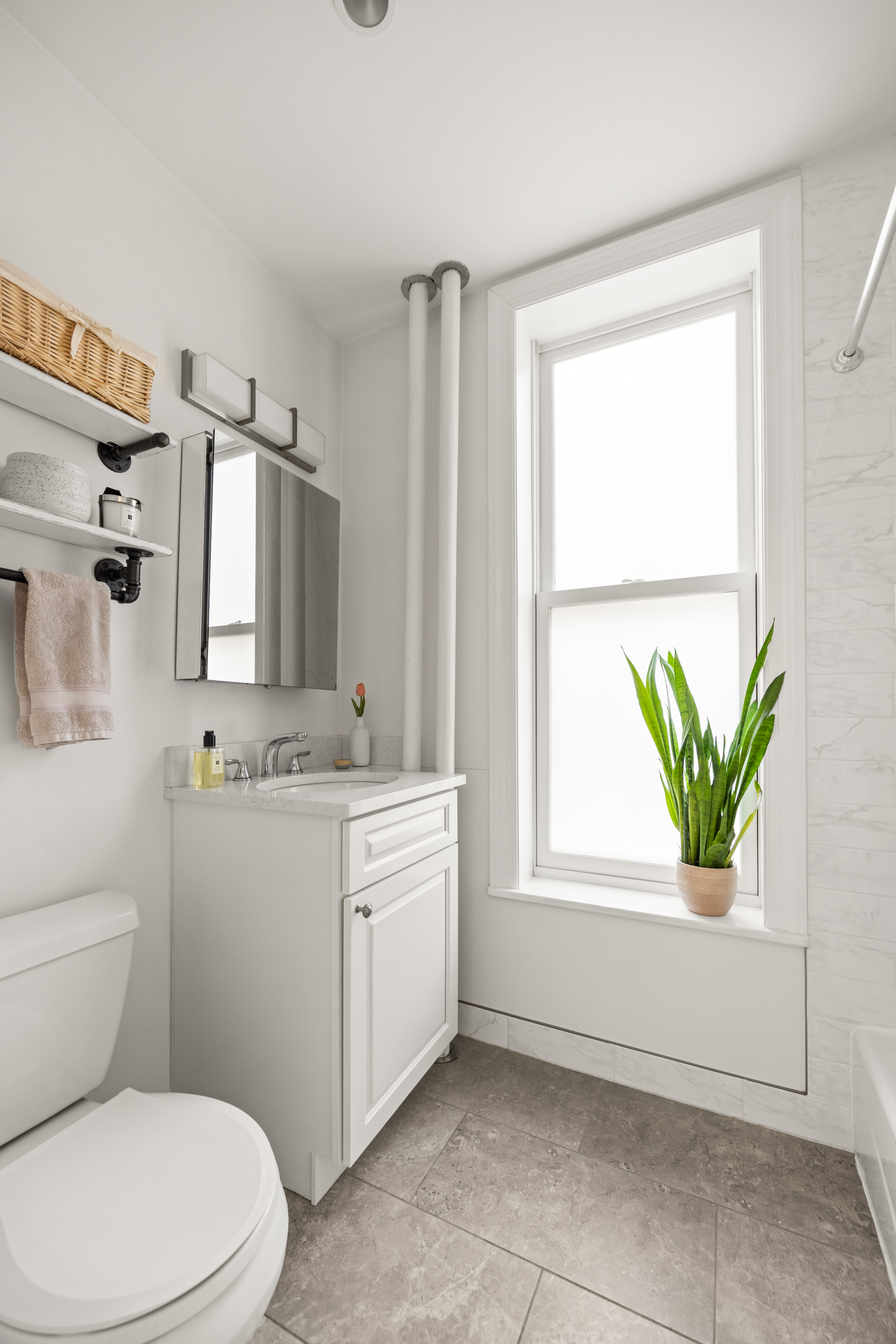 570 7th Street, Unit 3B Brooklyn, NY 11215 - Photo 7 of 9 a bathroom with a granite countertop toilet a sink and a window