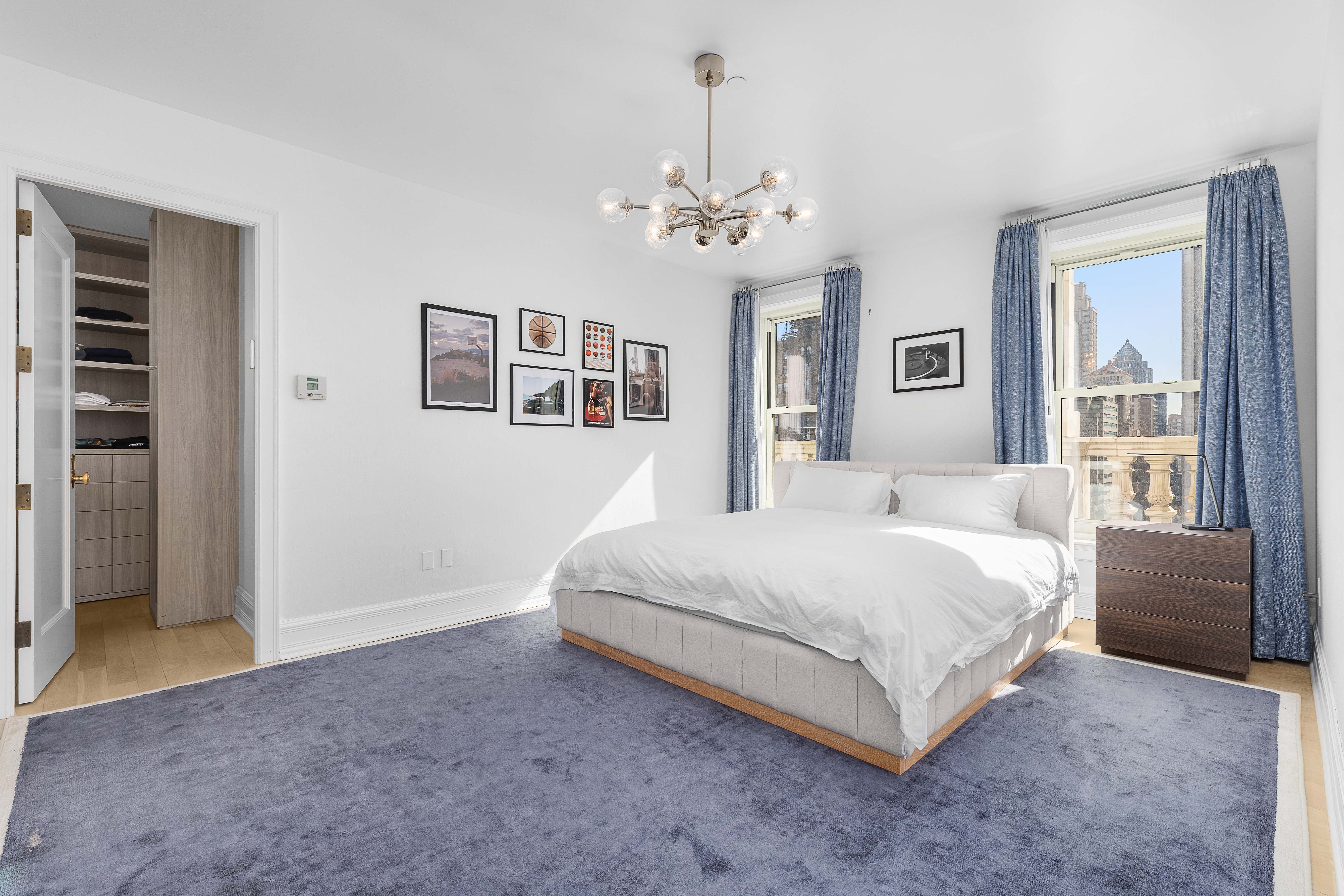 1 Central Park South, Unit 1511/1513 Manhattan, NY 10019 - Photo 6 of 25 a spacious bedroom with a large bed chandelier and windows
