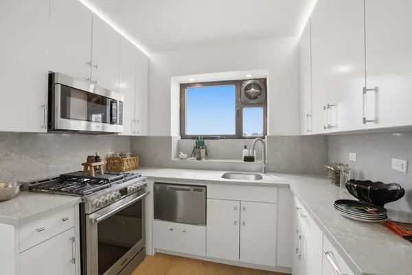 a kitchen with stainless steel appliances granite countertop white cabinets a sink and dishwasher