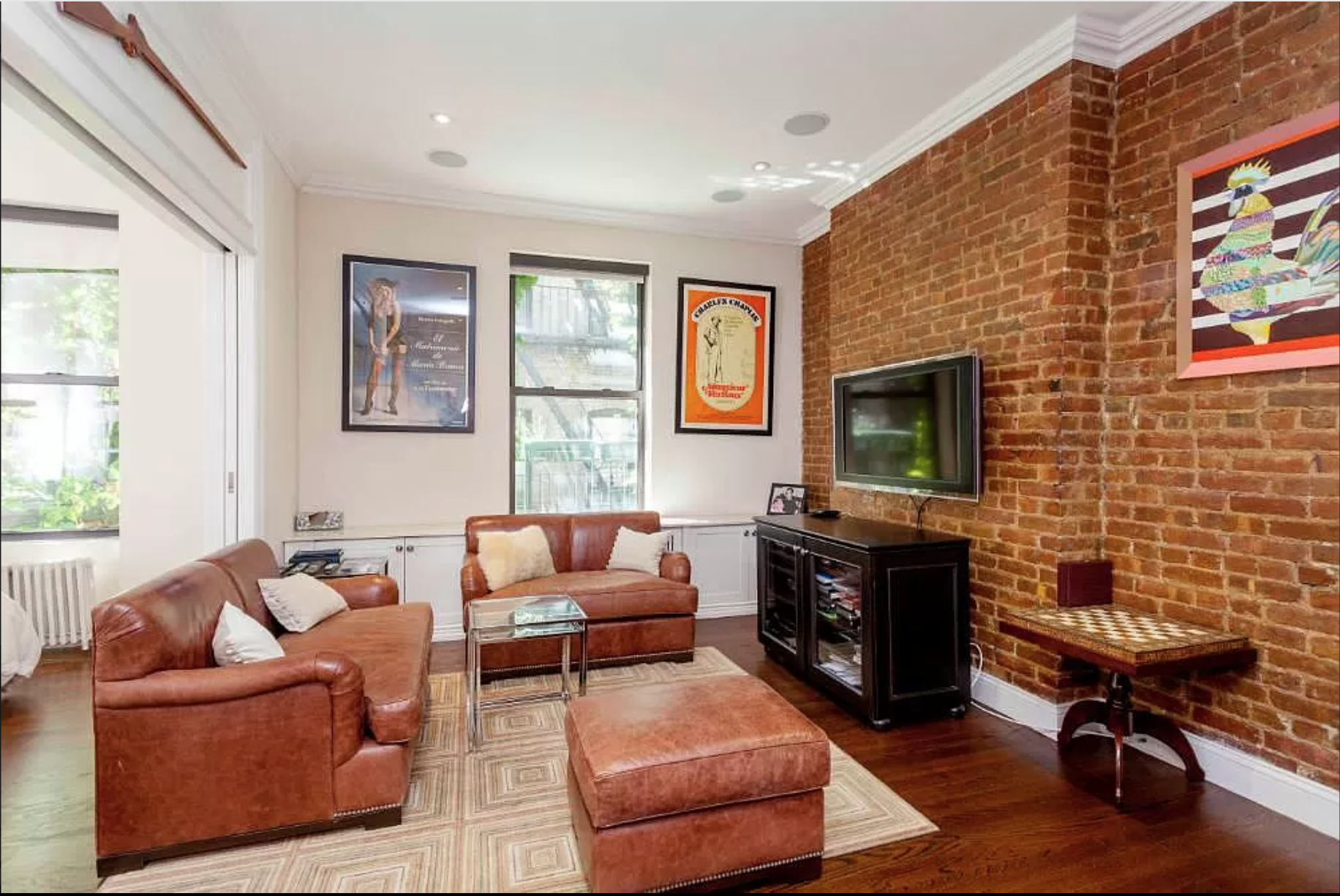 80 Charles Street, Unit 2R Manhattan, NY 10014 - Photo 1 of 5 a living room with furniture a flat screen tv and a fireplace