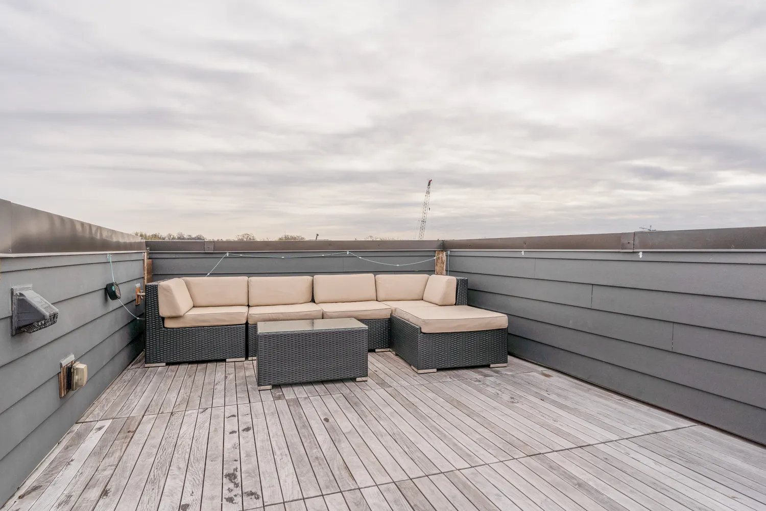 a view of roof deck with couches and wooden floor