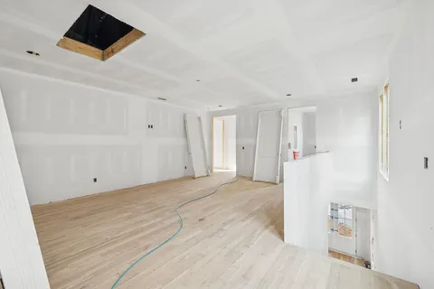 a view of a room with wooden floor and a bathroom