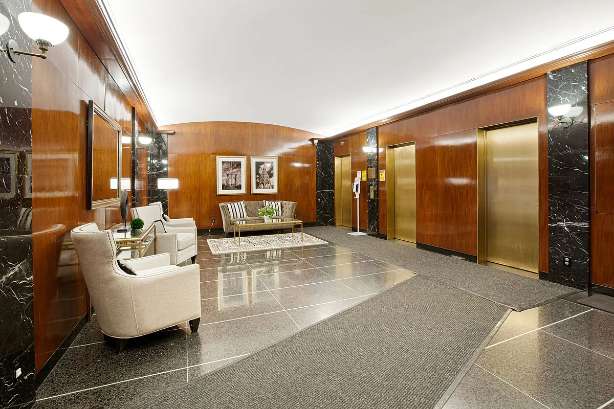 130 East 63rd Street, Unit 3D Manhattan, NY 10065 - Photo 11 of 13 a lobby with furniture and a large mirror