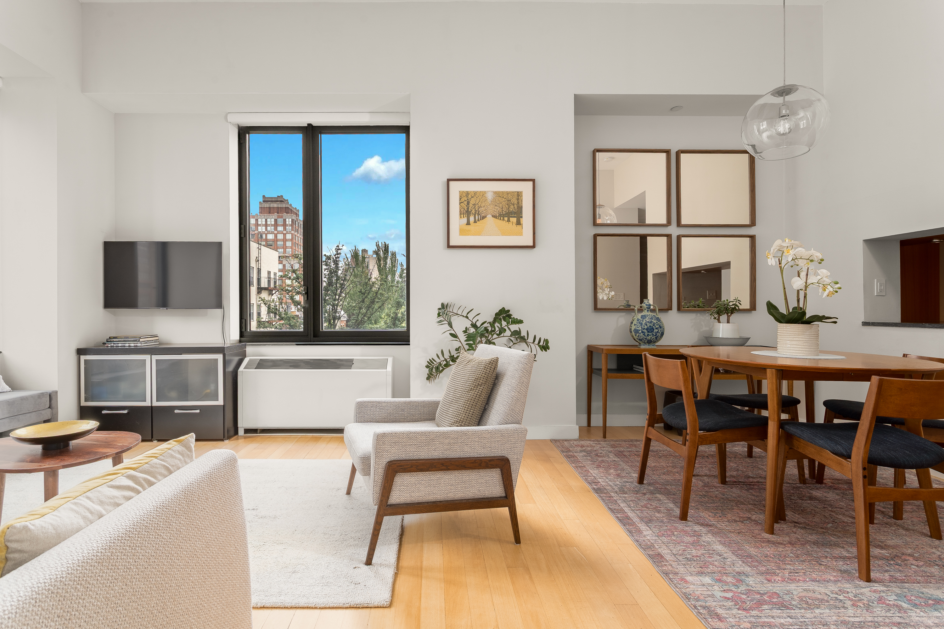 450 East 83rd Street, Unit 5K Manhattan, NY 10028 - Photo 4 of 16 a living room with furniture a flat screen tv and a fireplace