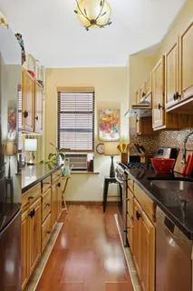 a kitchen with stainless steel appliances granite countertop sink stove top oven and cabinets
