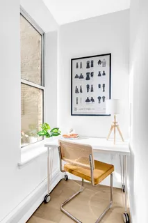 a living room with a table and a painting on the wall