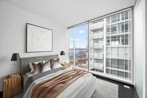 a bedroom with bed and a large window