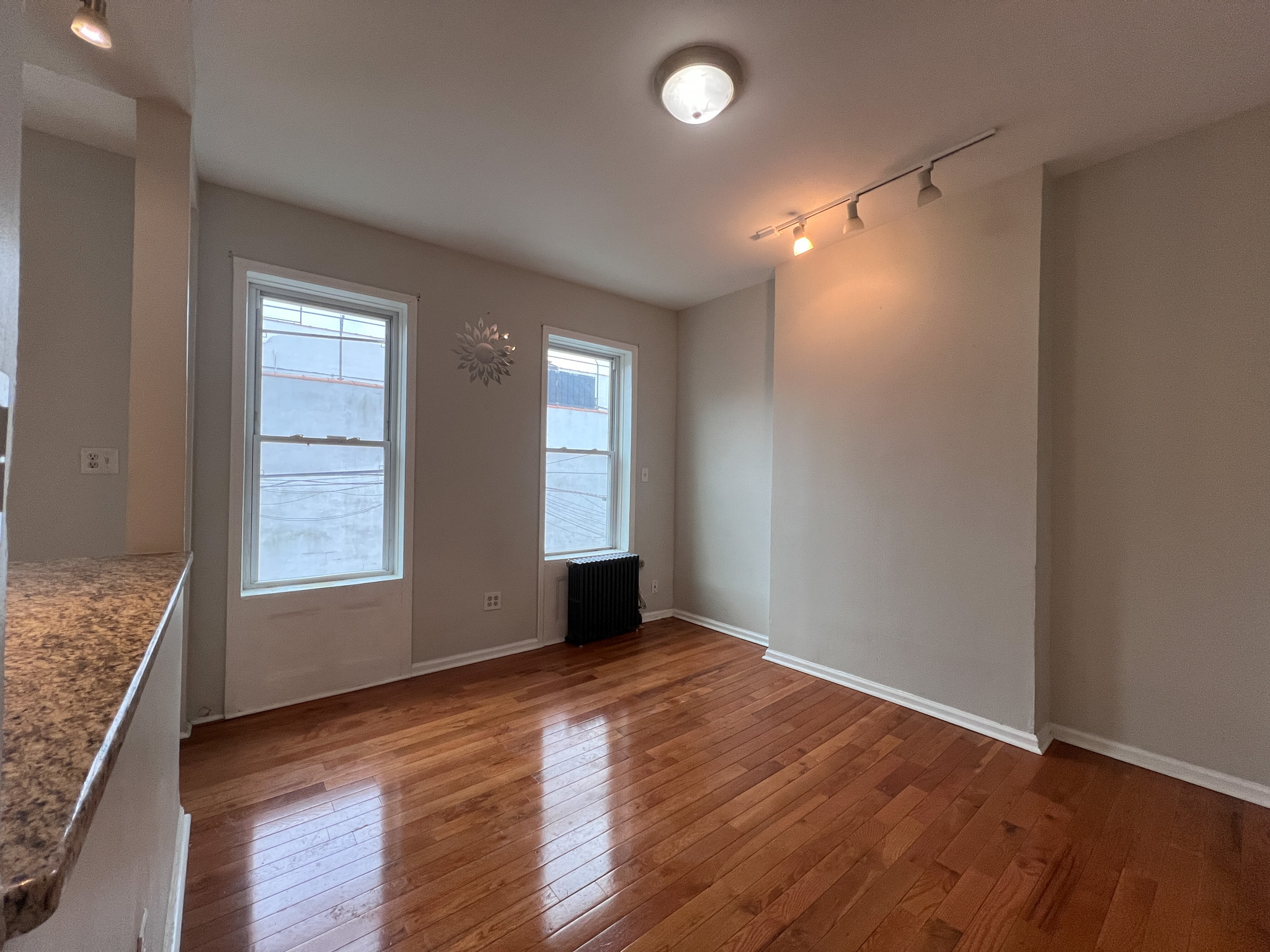 236 45th Street, Unit 2 Brooklyn, NY 11220 - Photo 3 of 8 an empty room with wooden floor and windows