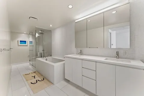 a spacious bathroom with a double sink mirror and bathtub