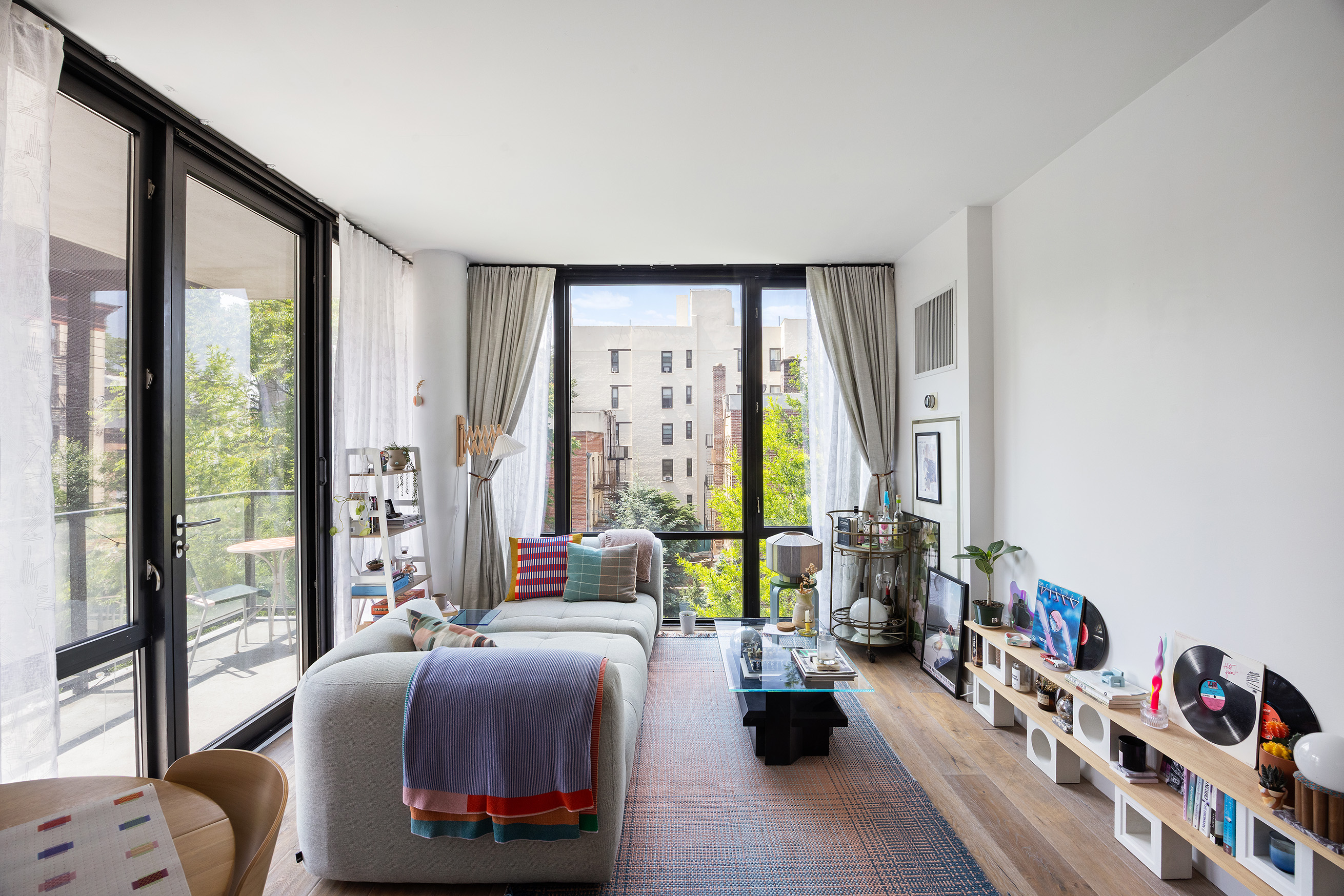 215 Avenue B, Unit 4A Manhattan, NY 10009 - Photo 2 of 13 a bedroom with furniture and a large window