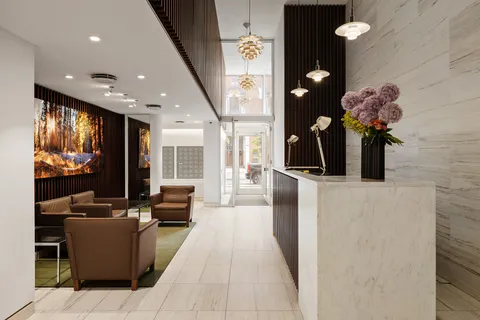 a lobby with furniture and potted plants