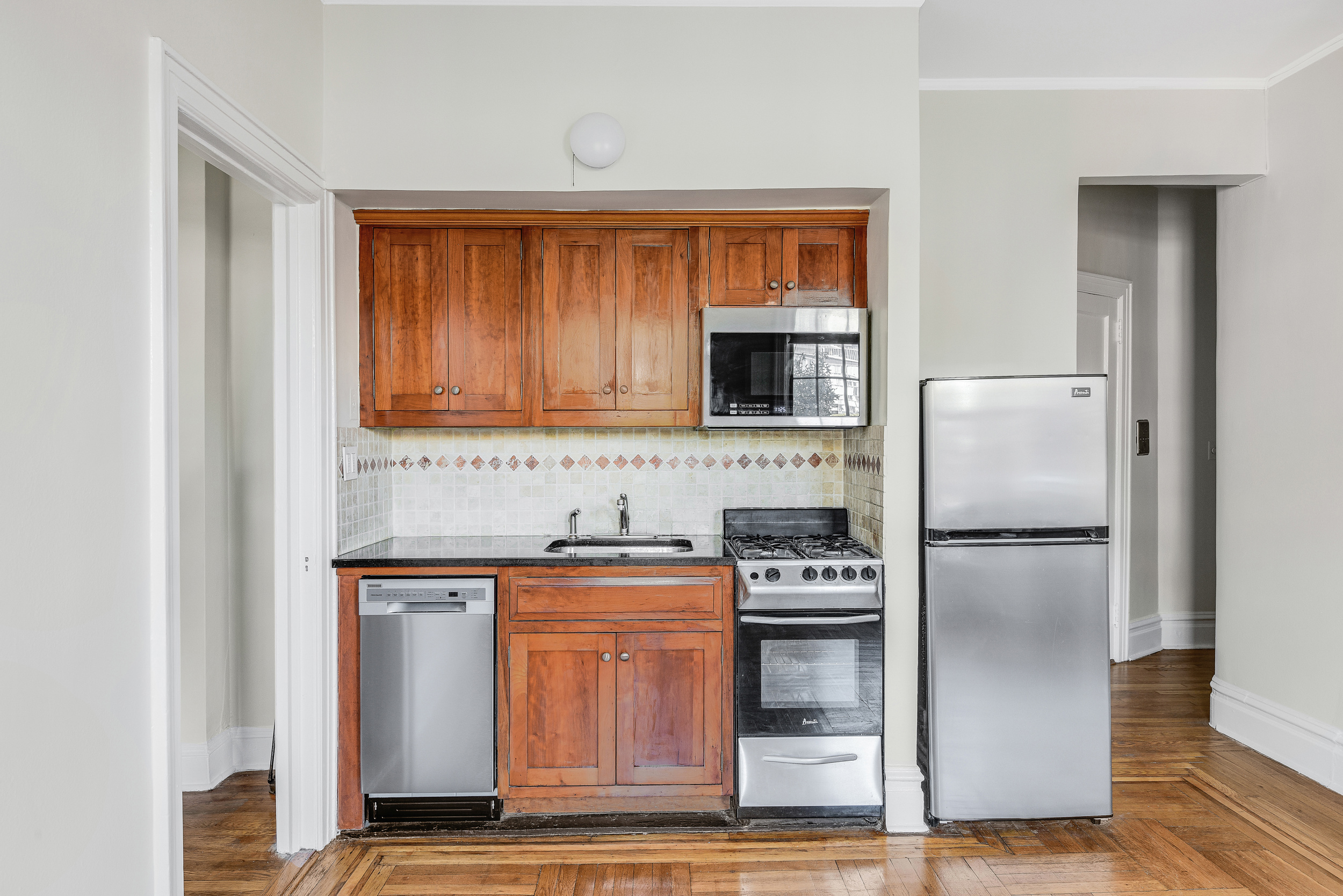 344 West 12th Street, Unit 5C Manhattan, NY 10014 - Photo 4 of 11 a kitchen with stainless steel appliances a refrigerator and a sink