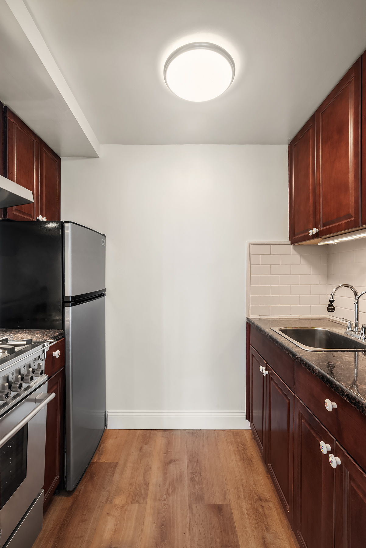 220 East 57th Street, Unit 17J Manhattan, NY 10022 - Photo 4 of 5 a kitchen with a sink a stove and a refrigerator