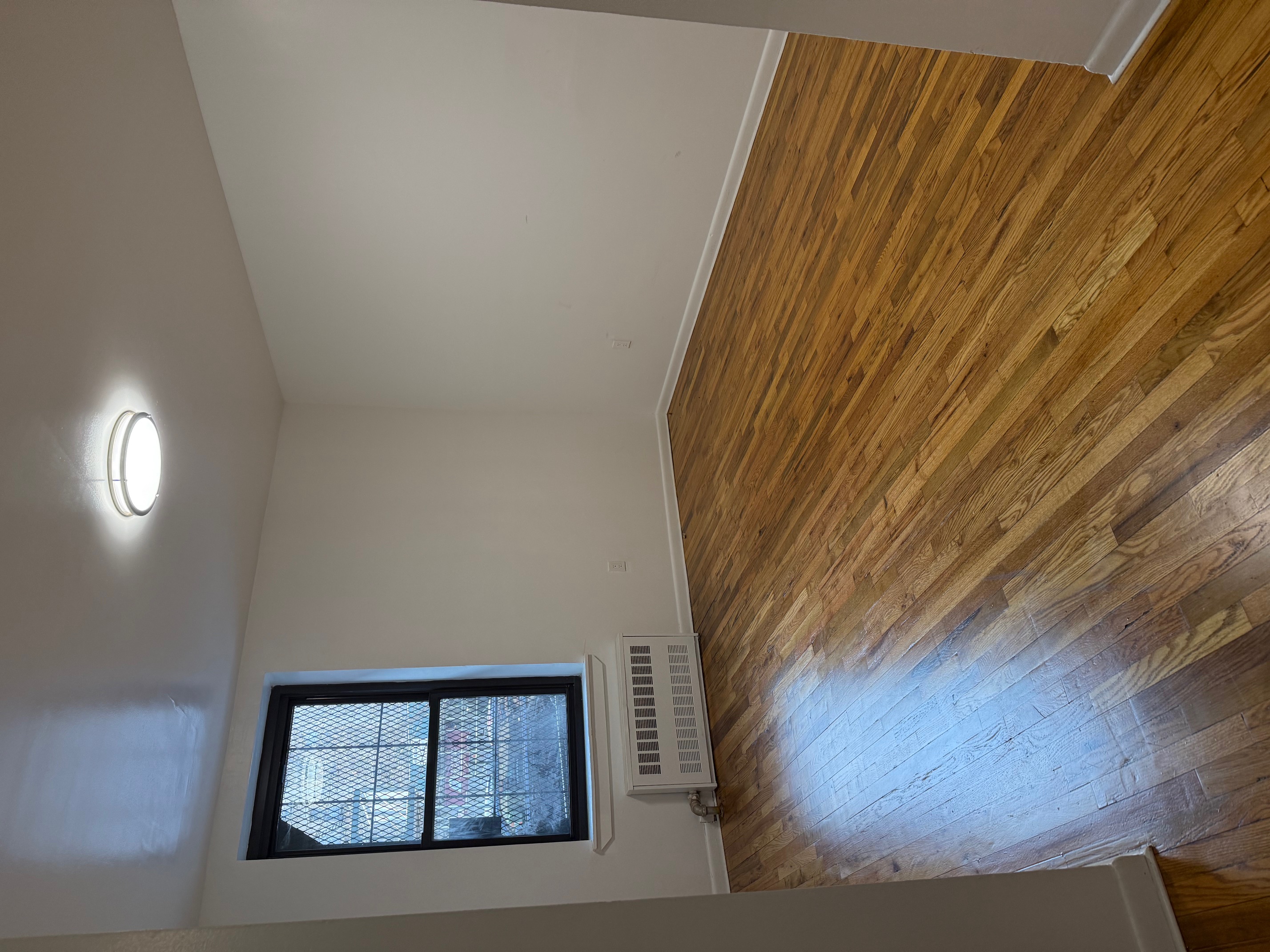 80 St Nicholas Avenue, Unit 1C Manhattan, NY 10026 - Photo 2 of 8 an empty room with wooden floor and windows