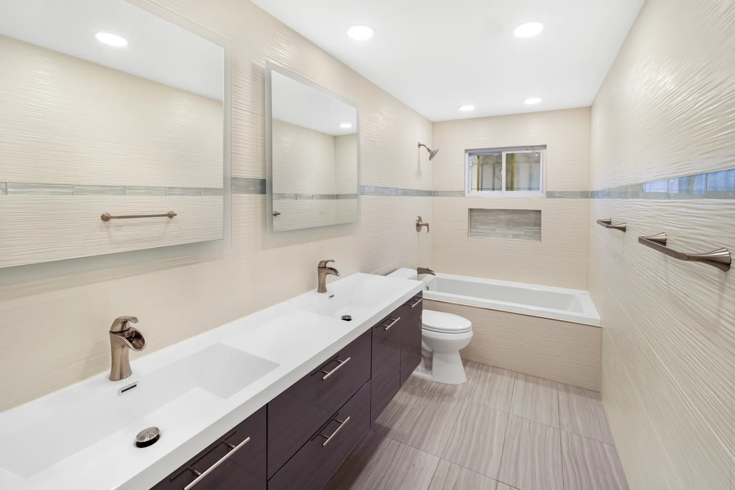 a bathroom with a double vanity sink toilet and a tub