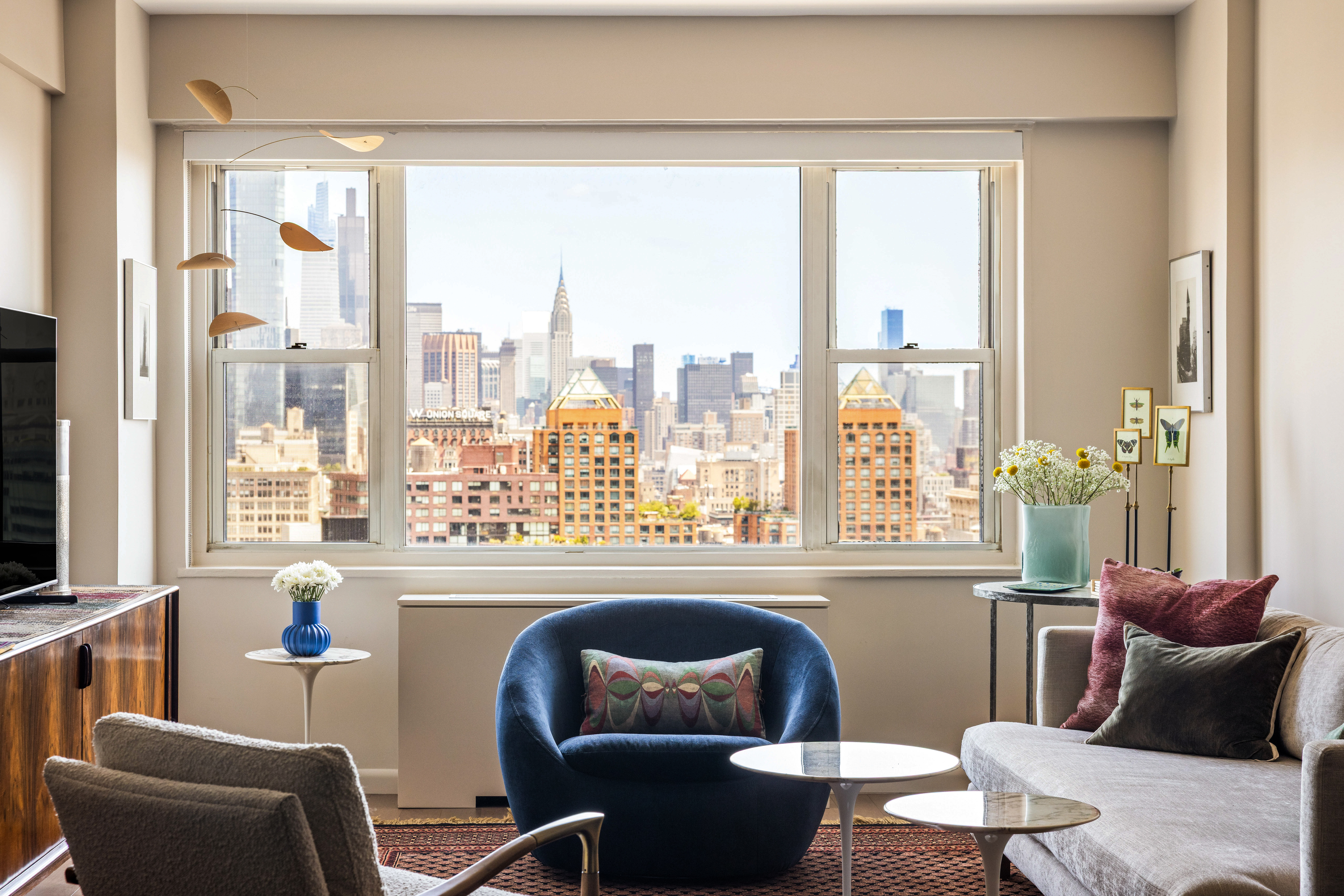 60 East 8th Street, Unit 30F Manhattan, NY 10003 - Photo 2 of 11 a living room with furniture and a large window