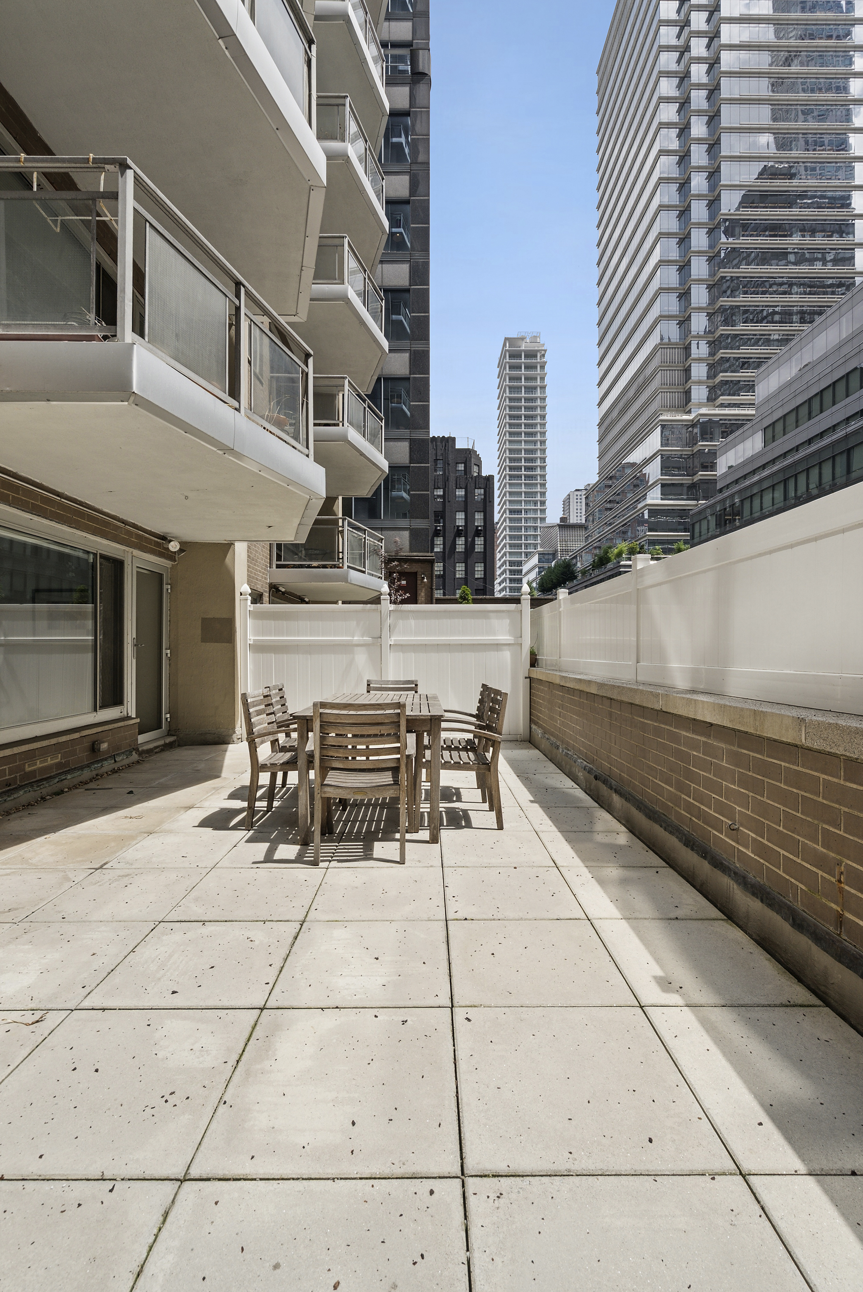 118 East 60th Street, Unit 4H Manhattan, NY 10022 - Photo 7 of 10 a view of a patio with a table and chairs and barbeque stove