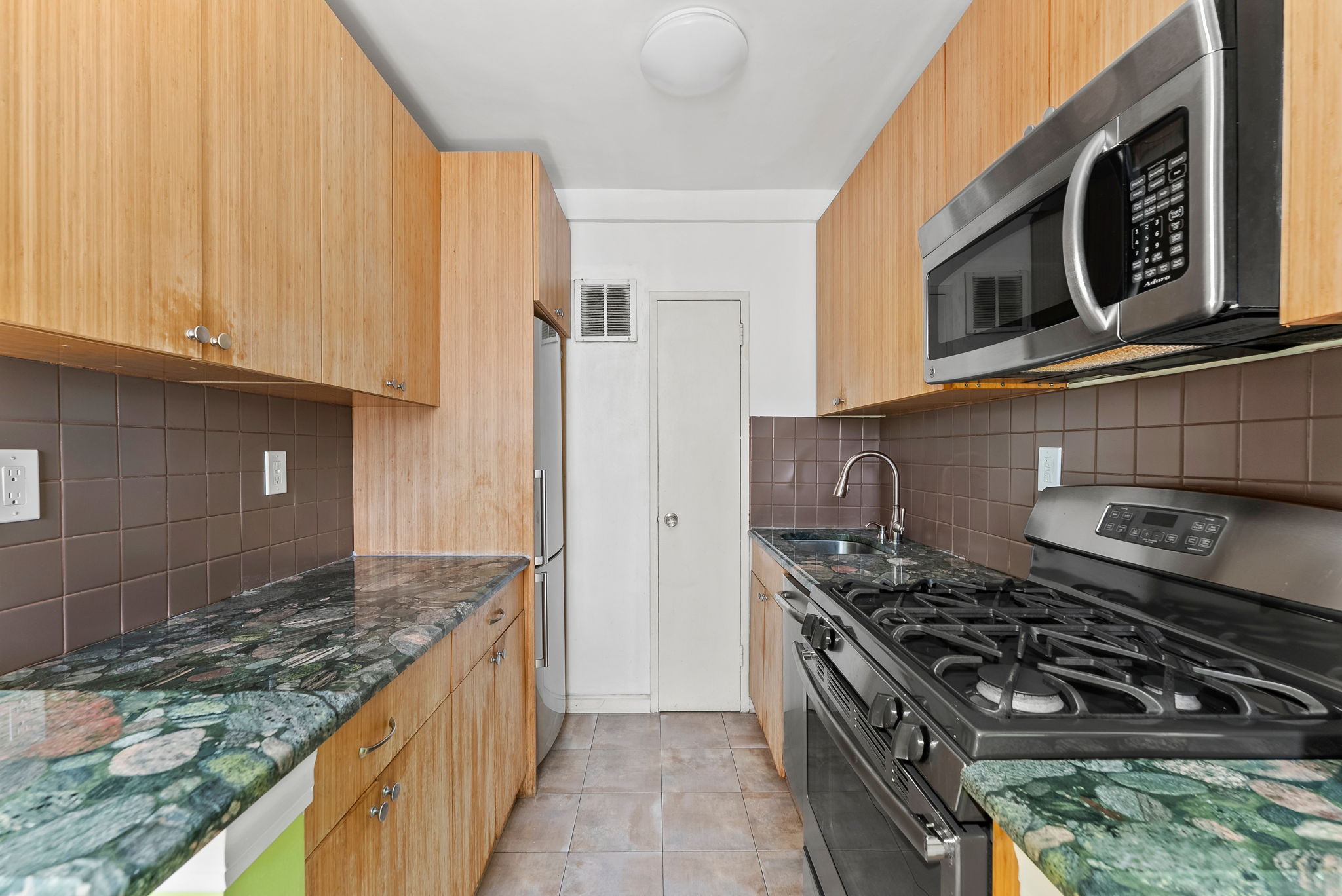 345 West 145th Street, Unit 11B2 Manhattan, NY 10031 - Photo 5 of 9 a kitchen with stainless steel appliances granite countertop a stove and a sink