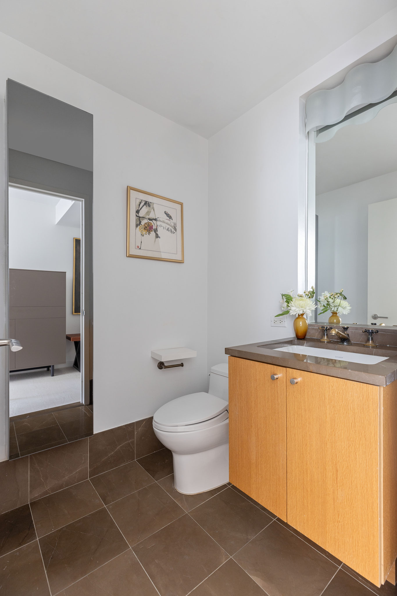 207 East 57th Street, Unit 14B Manhattan, NY 10022 - Photo 7 of 8 a bathroom with a granite countertop sink a toilet and a mirror